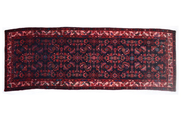 Decorative red and black patterned rug on a white background