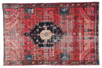 Red and black patterned rug on a white background