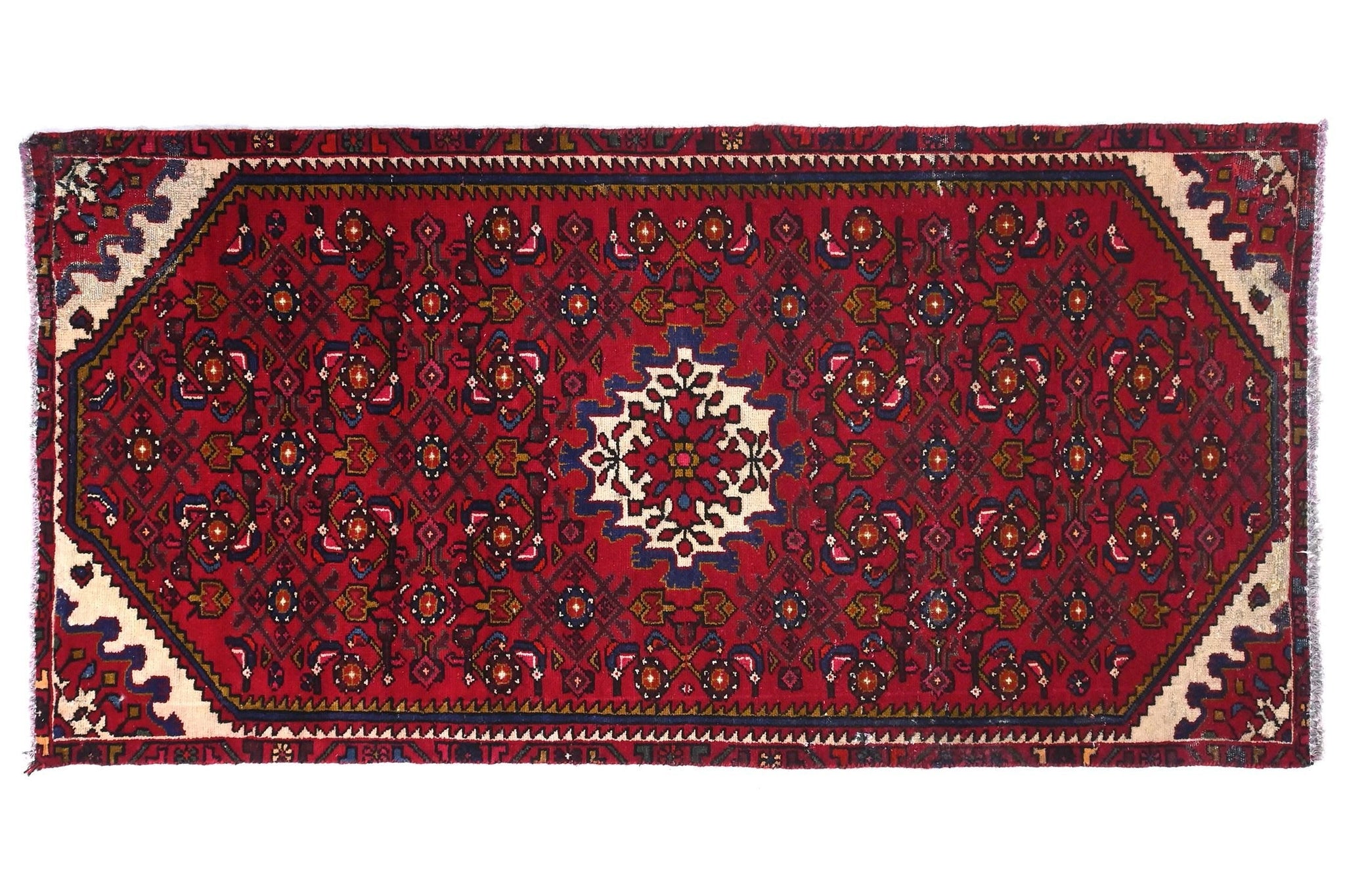 Red patterned rug with intricate designs on a white background