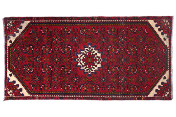 Red patterned rug with intricate designs on a white background