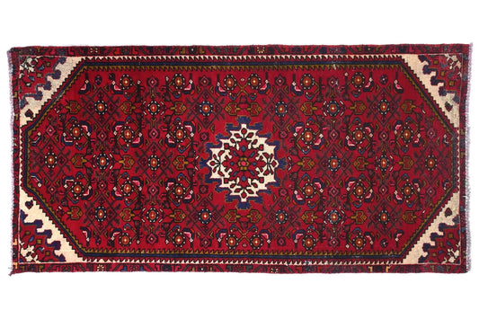 Red patterned rug with intricate designs on a white background
