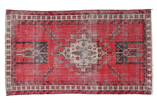 Red patterned rug with geometric design on a white background