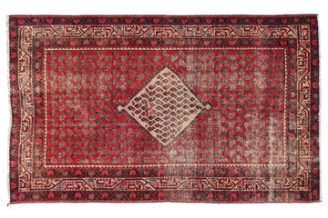 Red and brown patterned rug on a white background