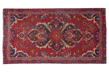 Decorative red rug with intricate patterns on a white background