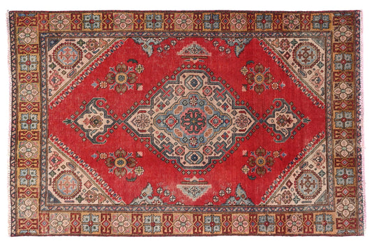 Decorative red rug with intricate patterns on a white background