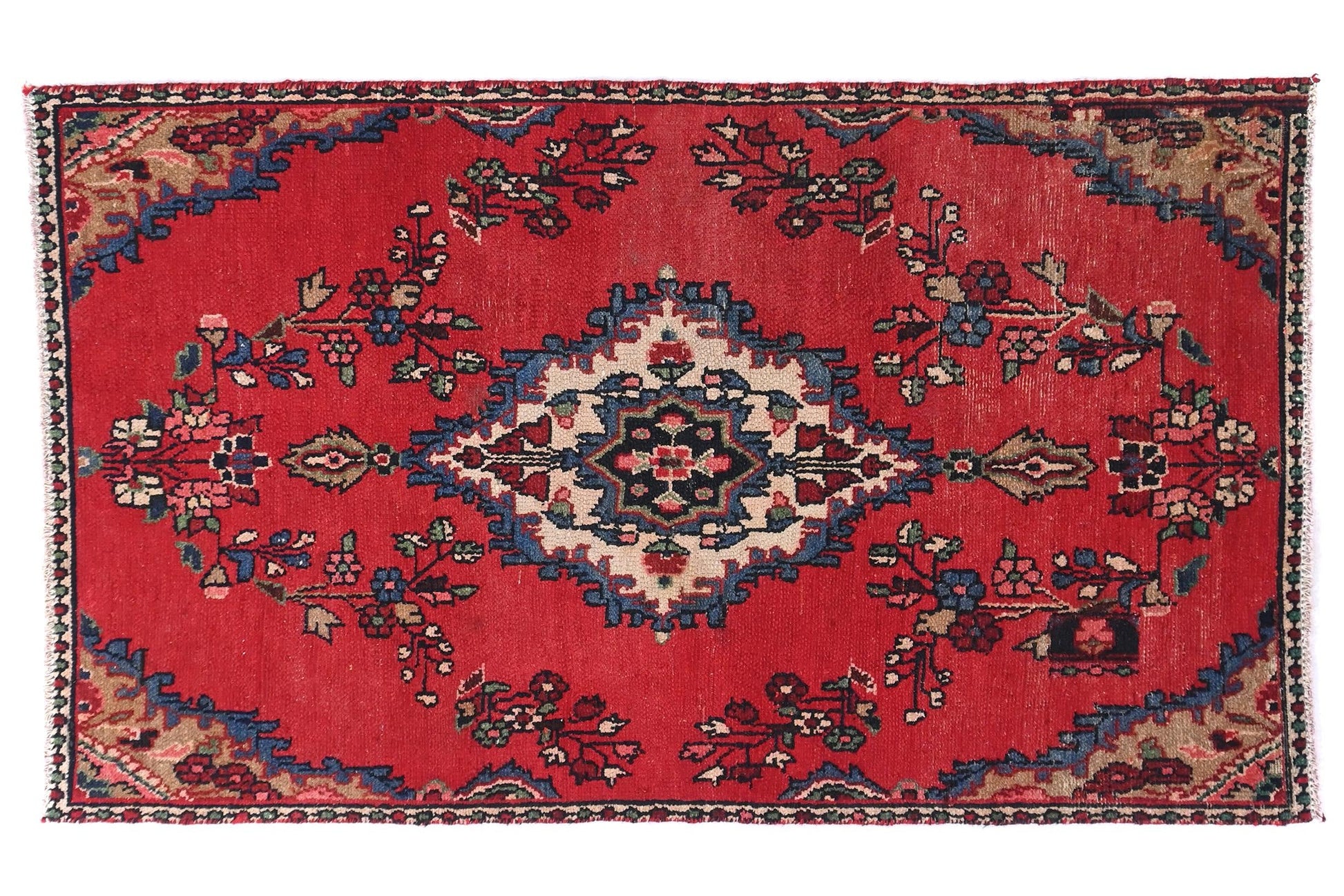 Decorative red rug with intricate patterns on a white background