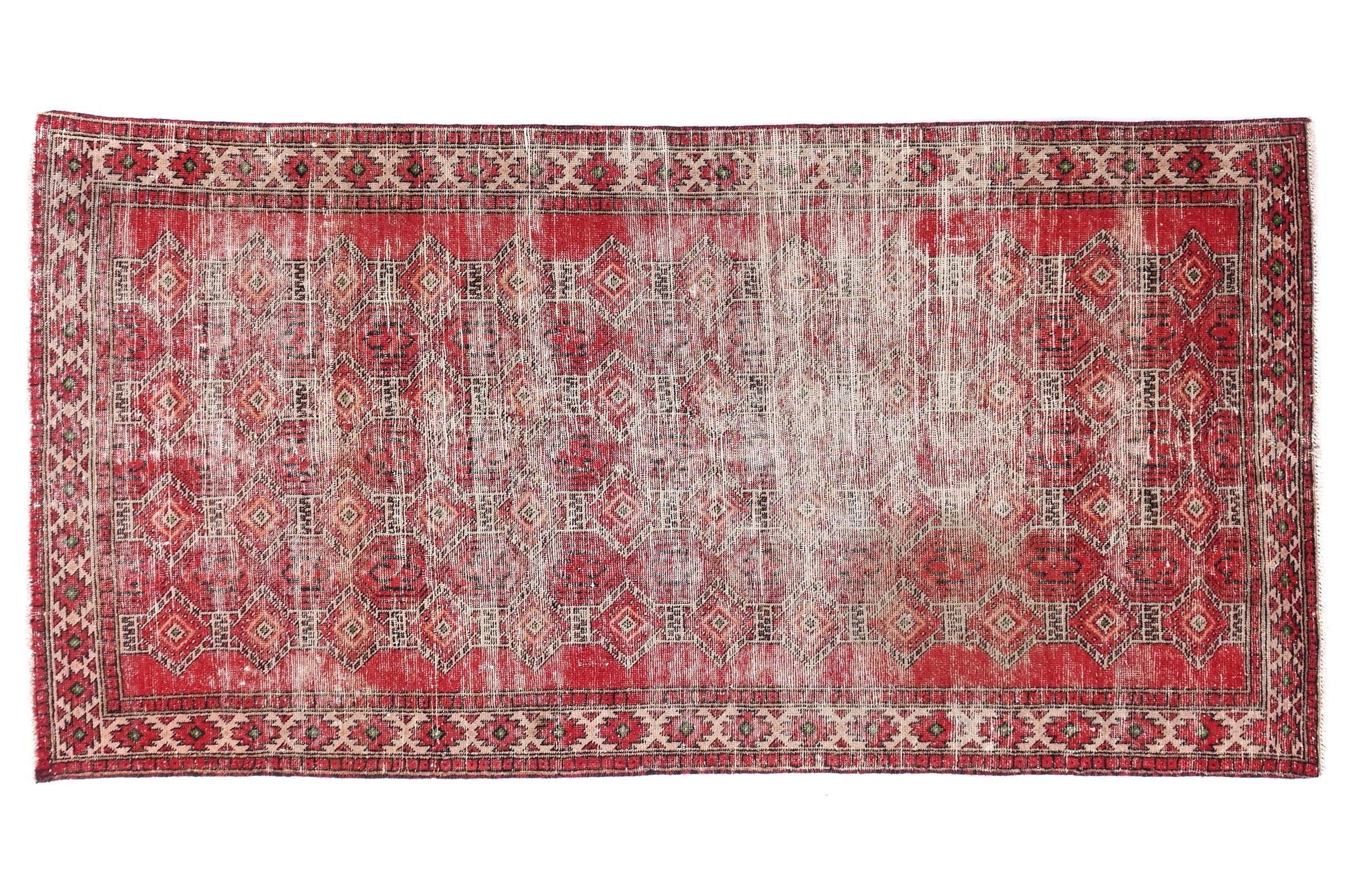 Red and beige patterned rug on a white background