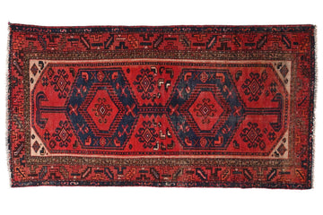 Red and black patterned rug on a white background