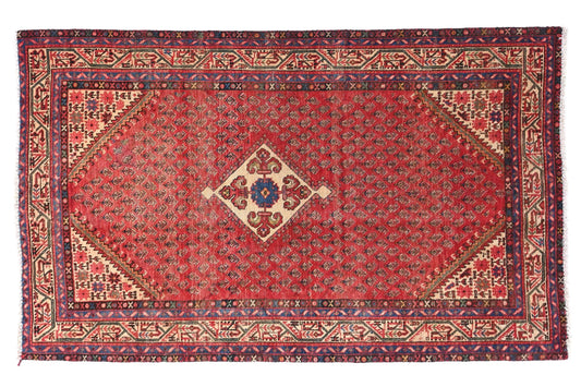 Red patterned rug with intricate designs on a white background