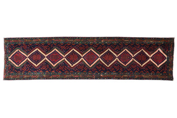 Long, narrow rug with geometric pattern on a white background