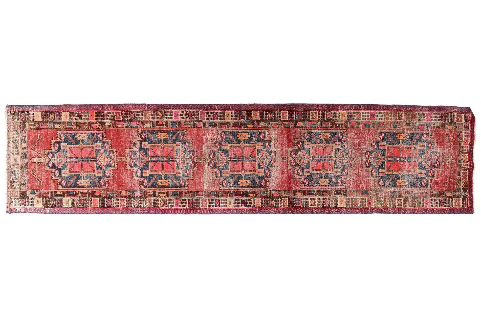 Long, narrow patterned rug on a white background