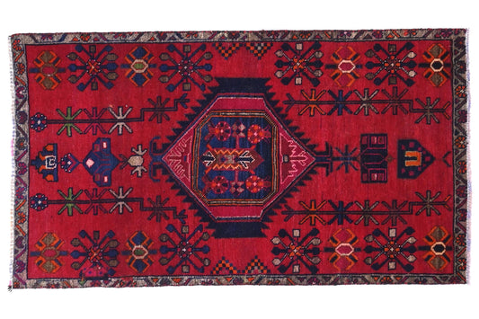 Red patterned rug with geometric design on a white background