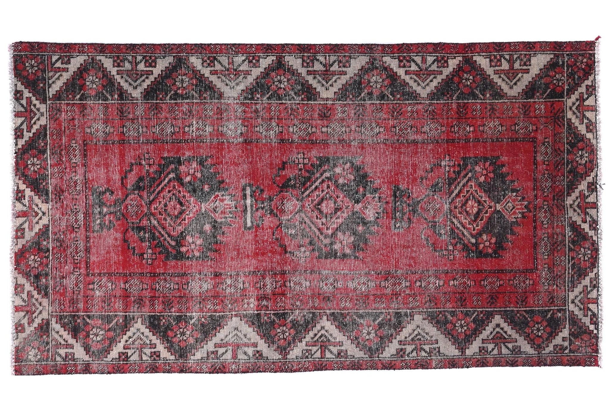 Red and black patterned rug on a white background