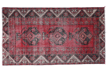 Red and black patterned rug on a white background