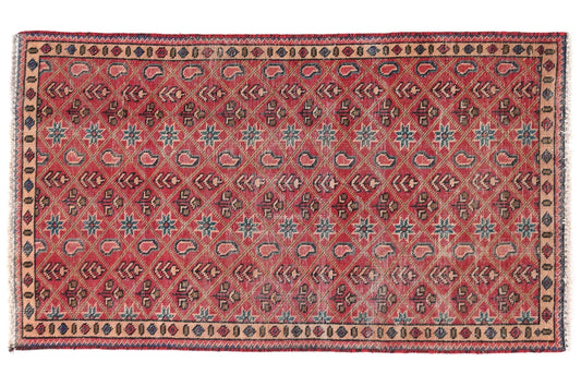 Decorative red rug with intricate patterns on a white background