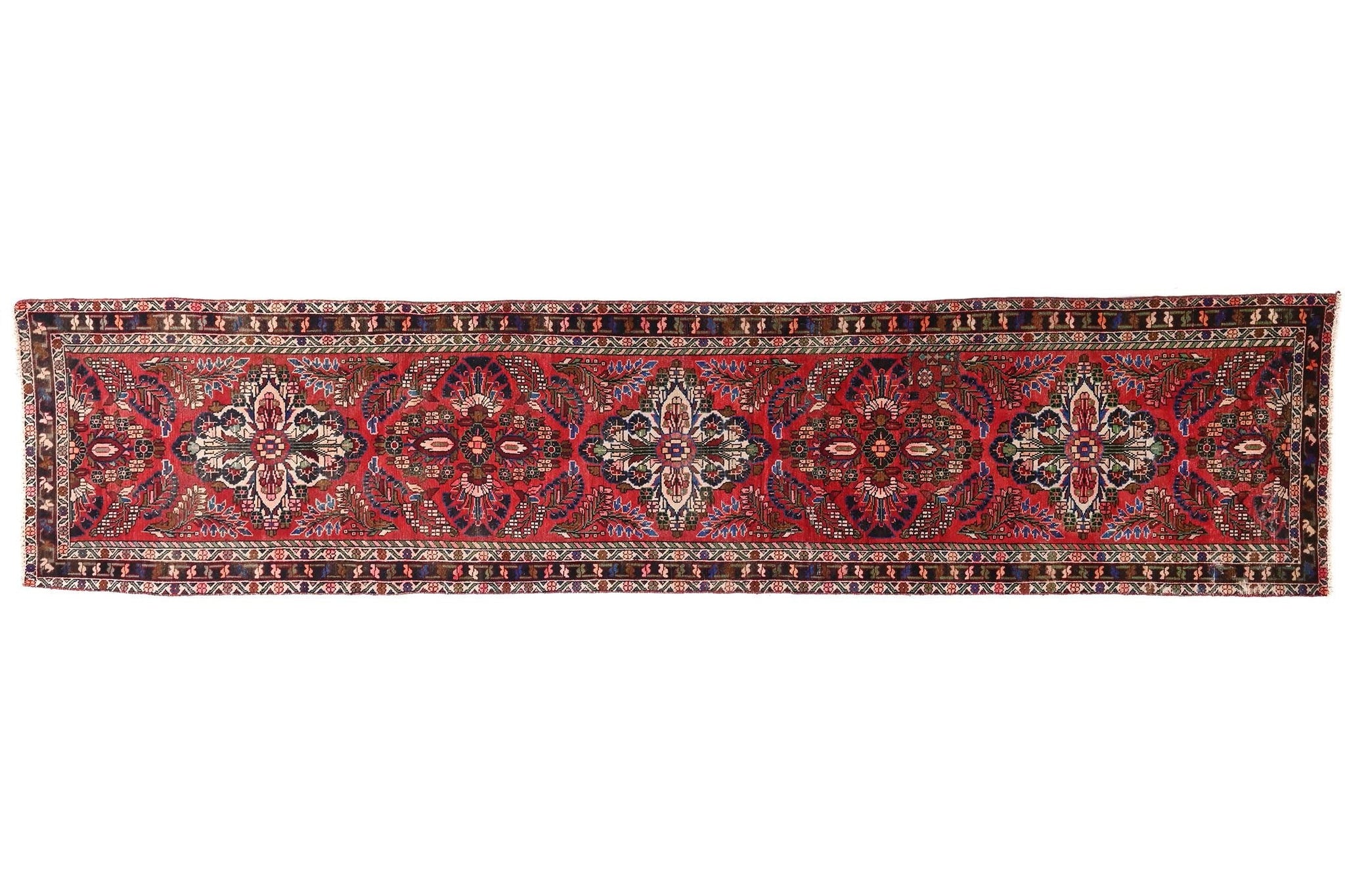 Long, narrow red and brown patterned rug on a white background